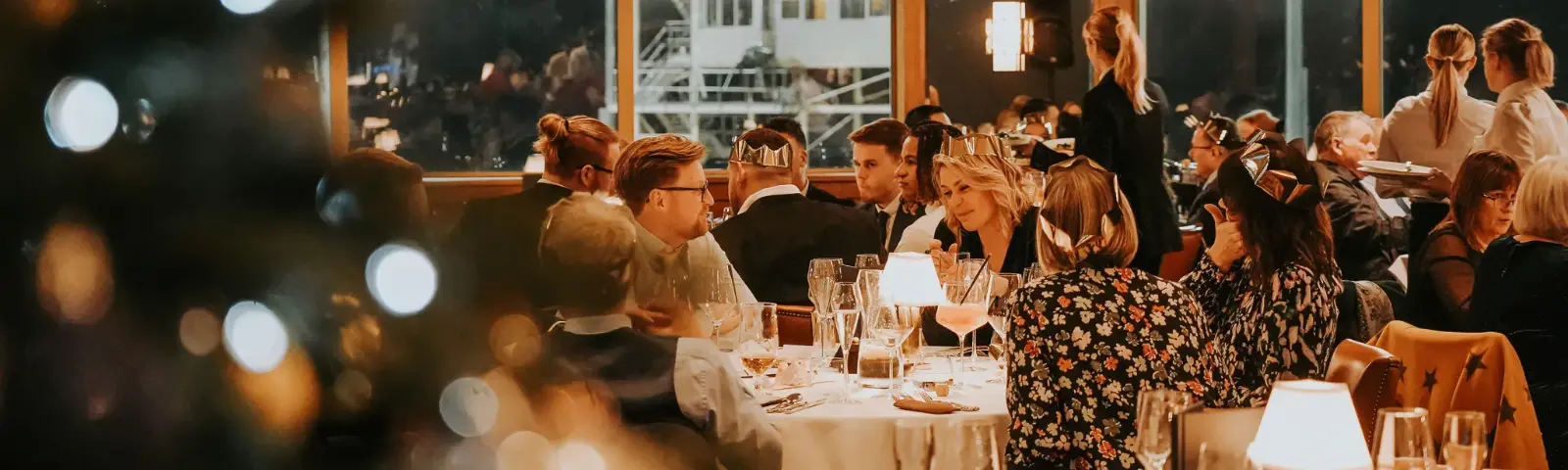 Crowds sitting at tables at a christmas party.