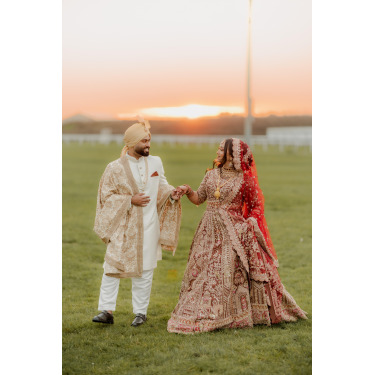 Asian newlyweds posing for a photo at sunset.