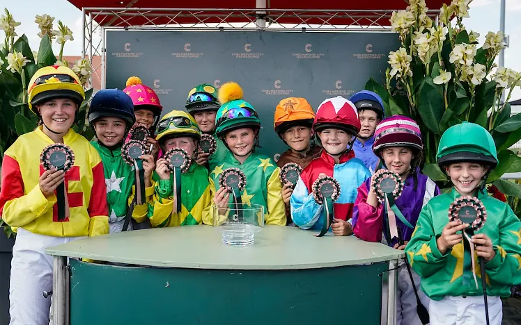 Children in racing silks proudly show off their awards 