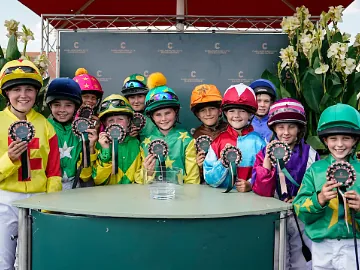 Children in racing silks proudly show off their awards 