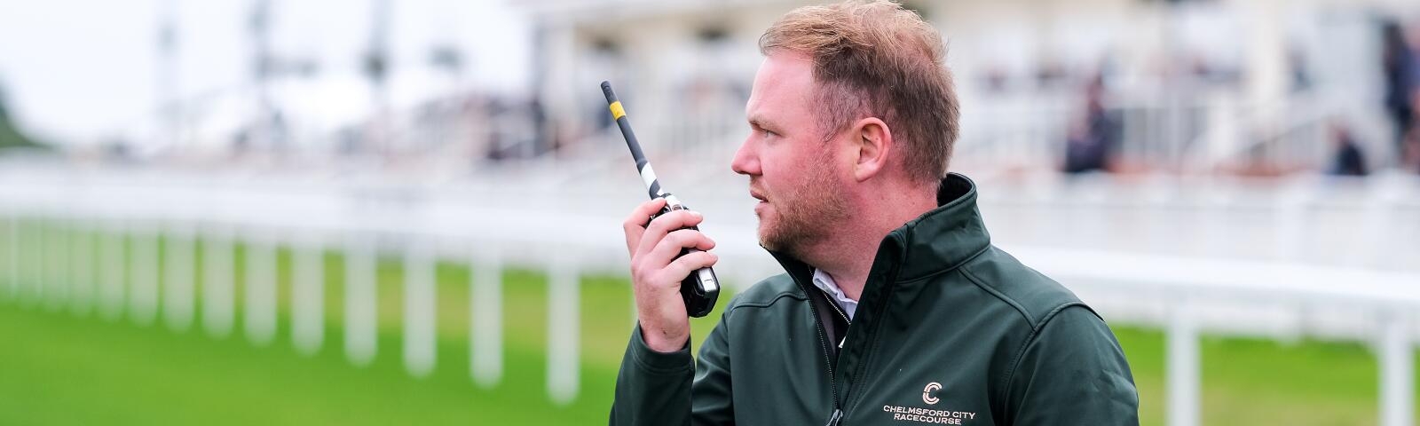 Team member at Chelmsford Racecourse talking via a walkie-talkie.